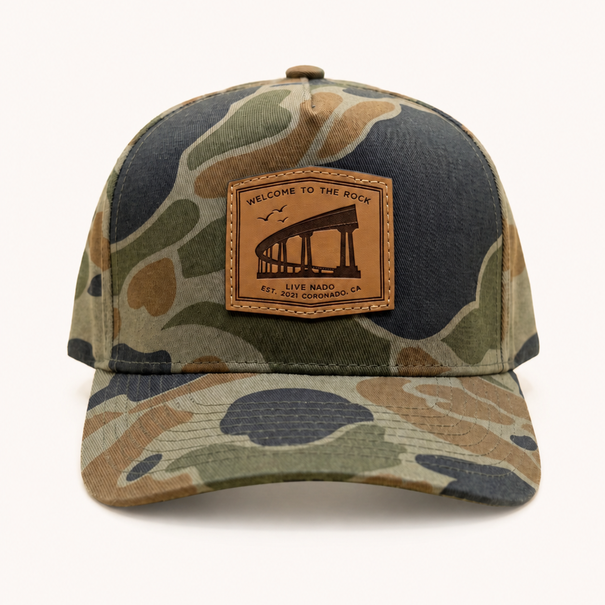 Camouflage baseball cap with leather patch on a white background