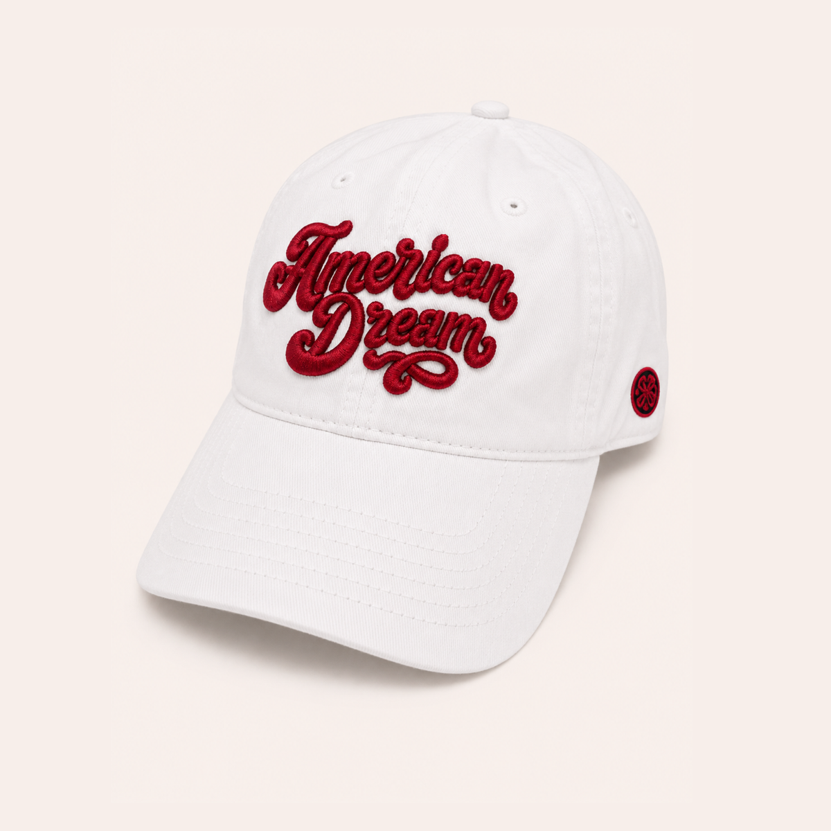 White baseball cap featuring "American Dream" embroidered in raised red script across the front.