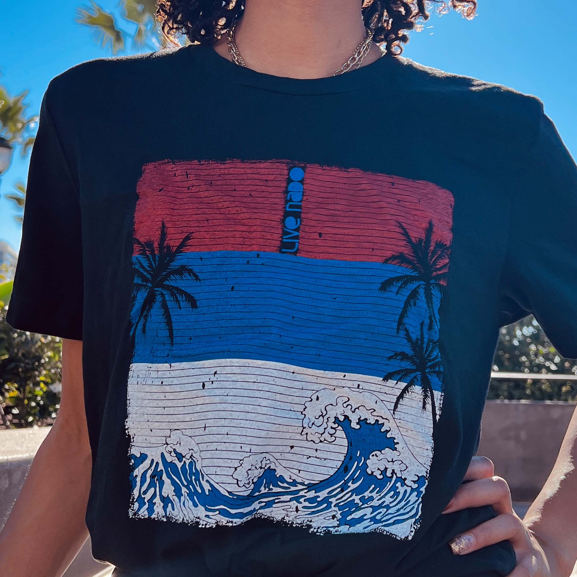 woman wearing black tshirt with red white and blue waves surf design from coronado california