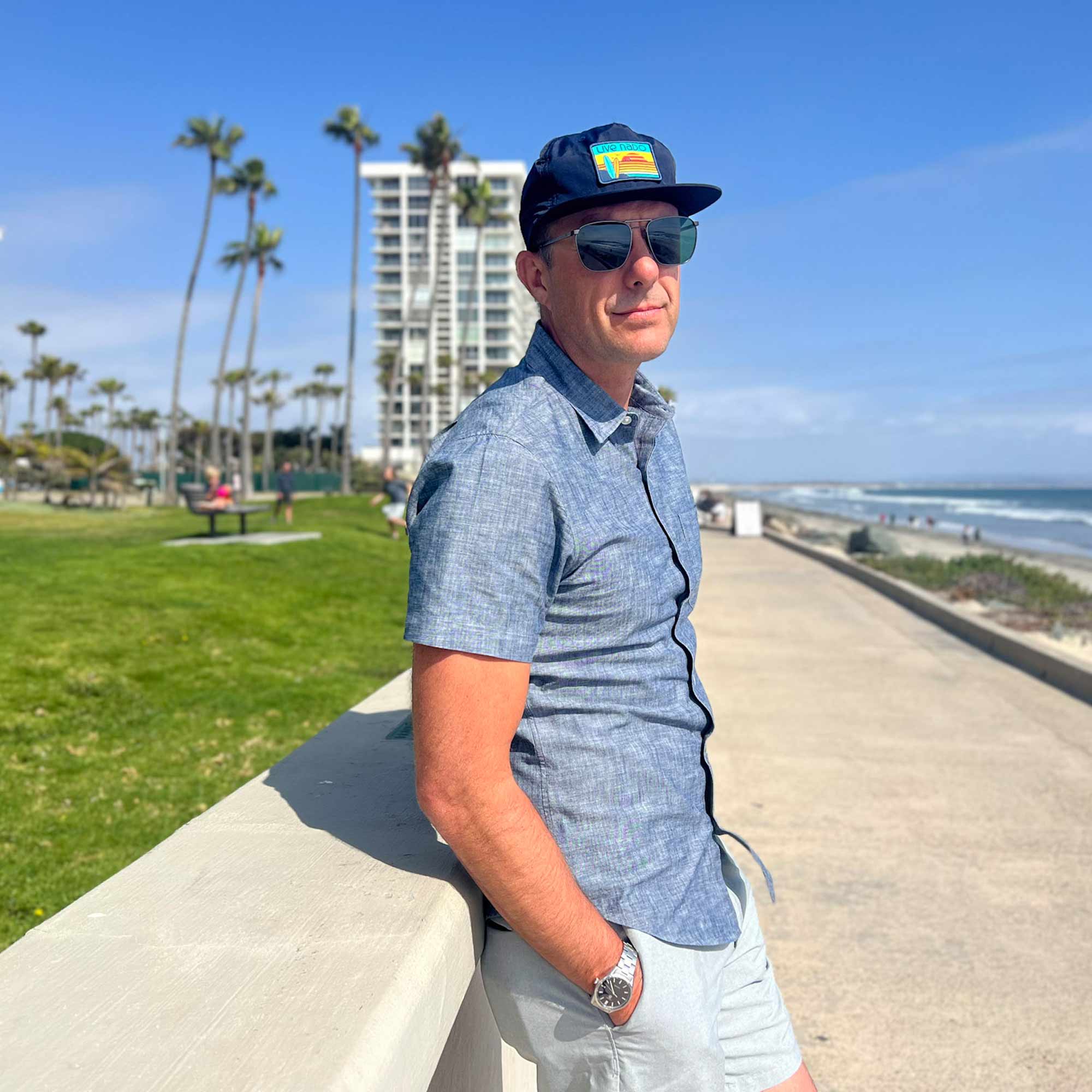 Man wearing navy blue flat brim surf cap standing on beach path near the coronado shores in coronado california