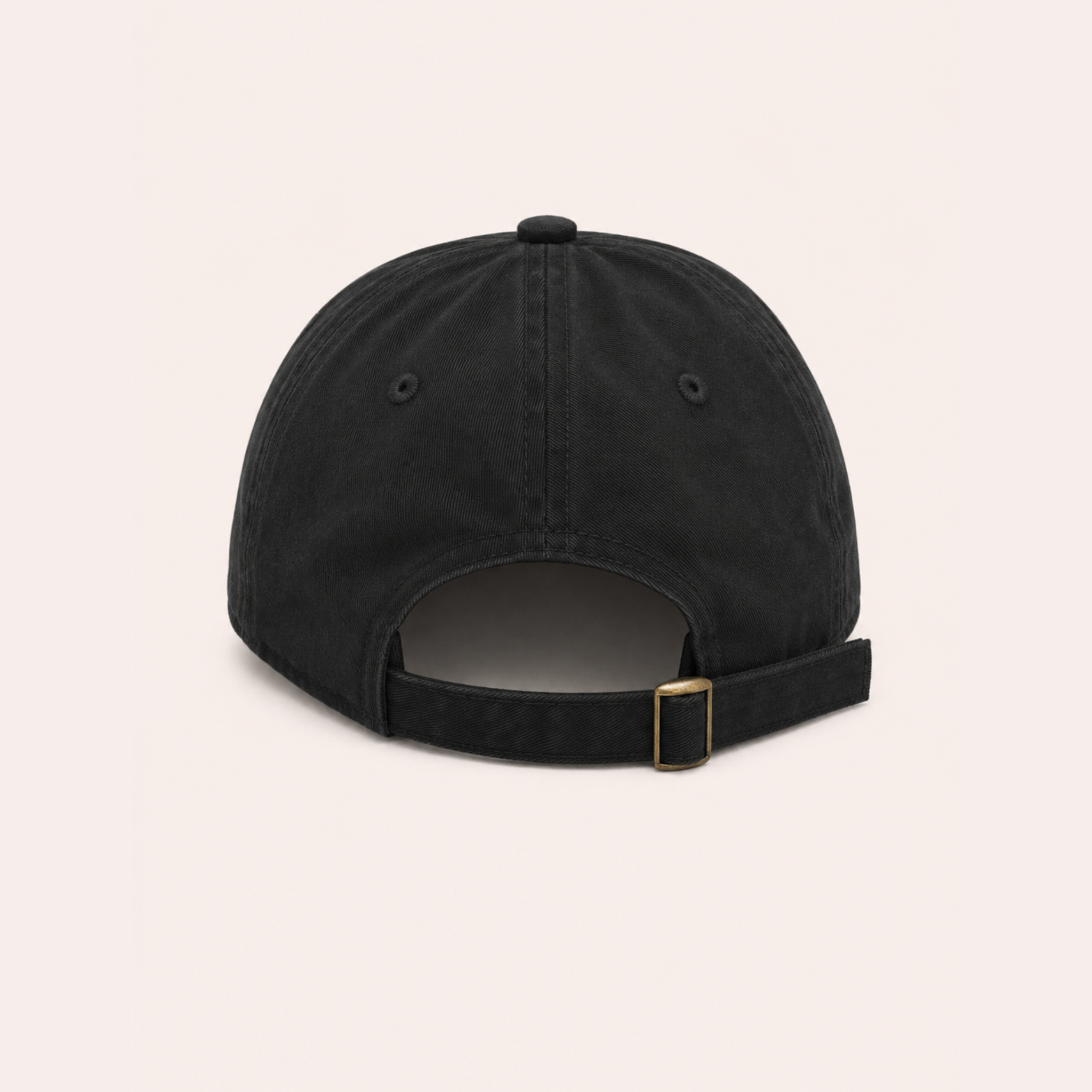 Back view of a black cotton baseball cap with an adjustable fabric strap and brass buckle.