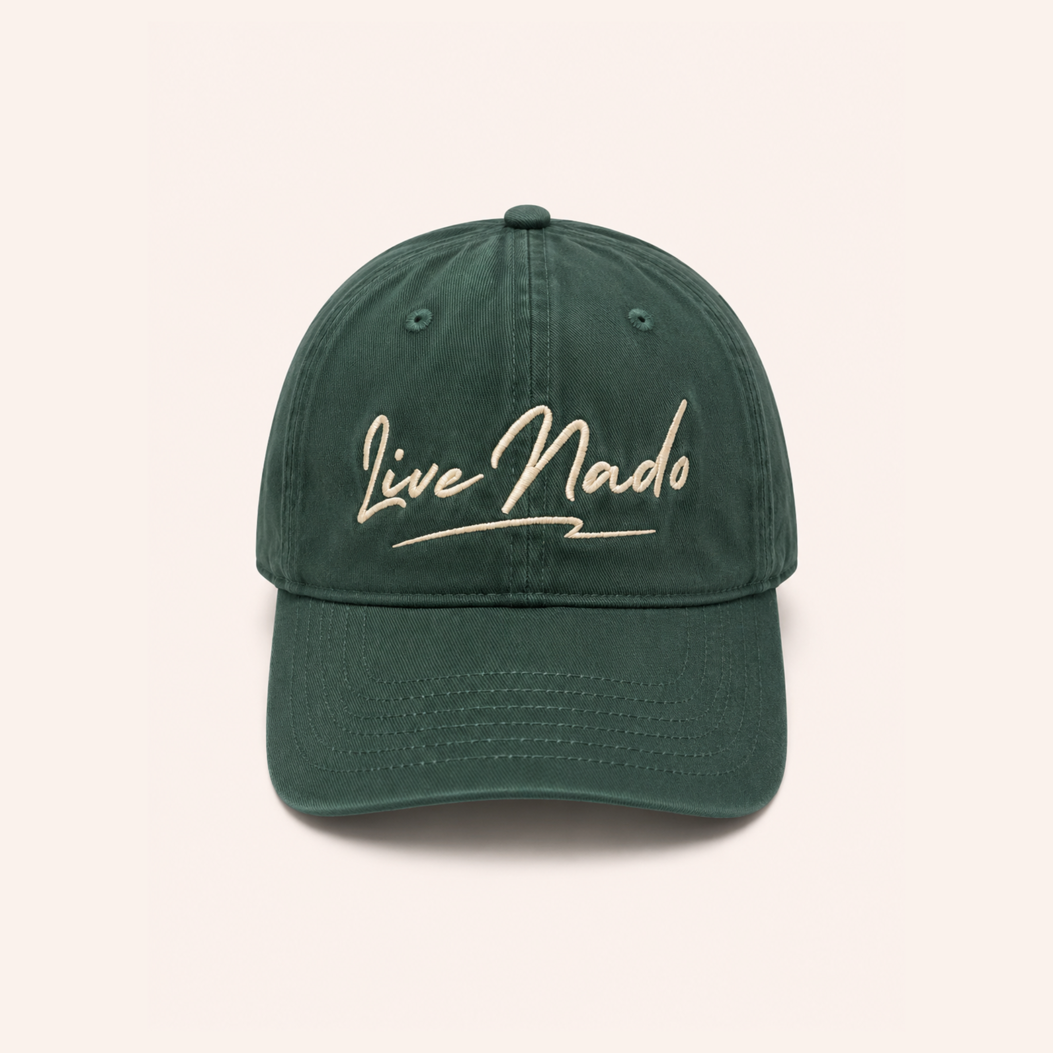 Front-facing view of a relaxed, washed dark green cotton baseball cap centered against an off-white background. The crown features off-white embroidered cursive text reading "Live Nado" with a stylized underline.