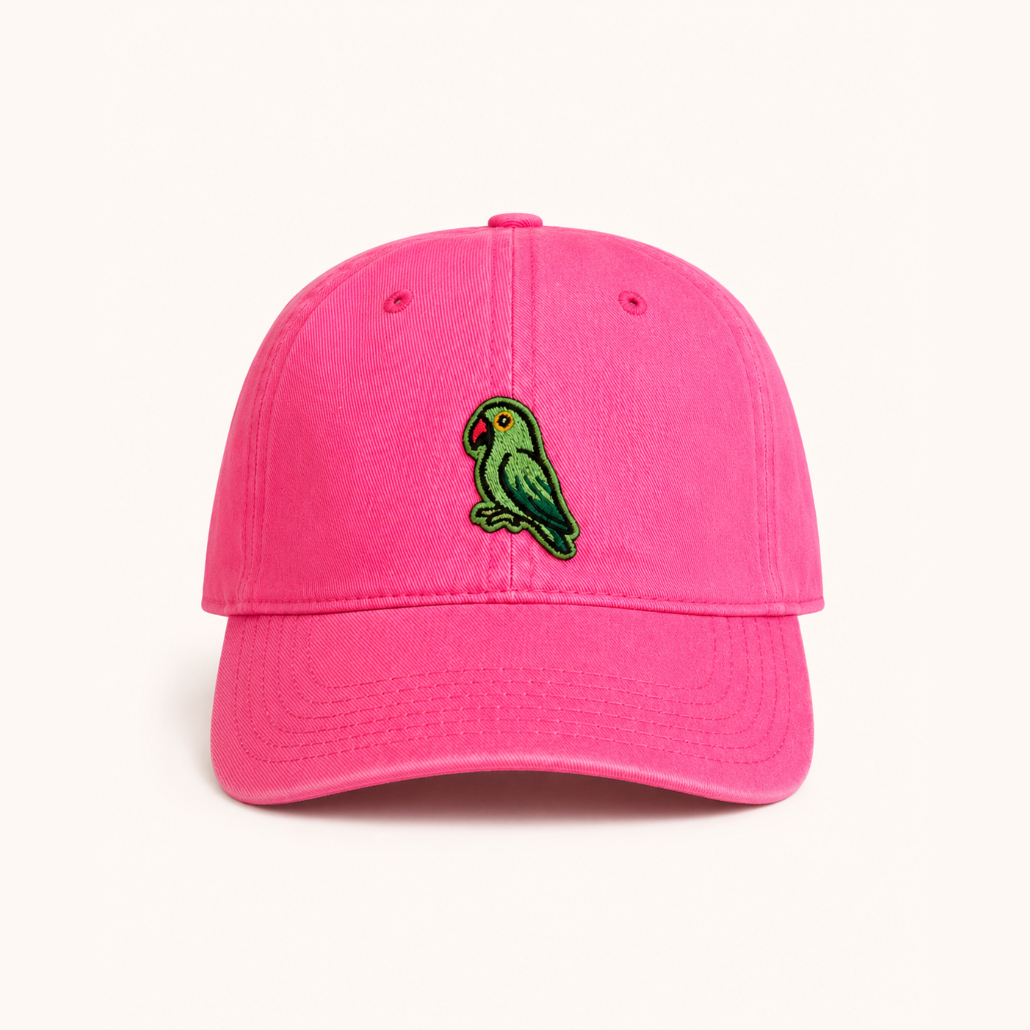 Pink cap with a green parrot emblem on a white background