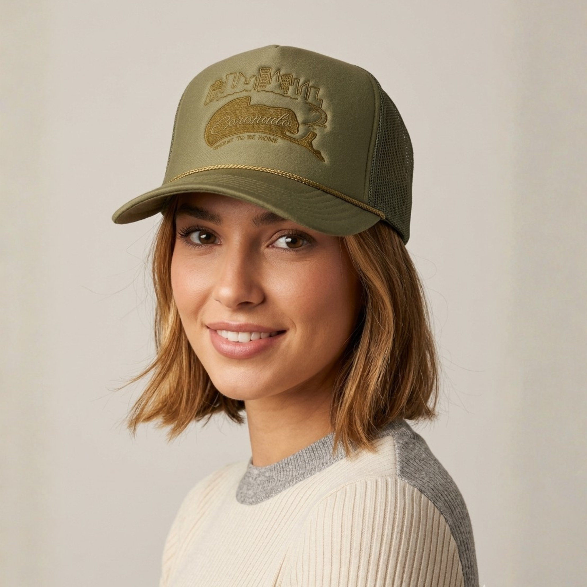 Woman wearing a green cap with a logo on a plain background