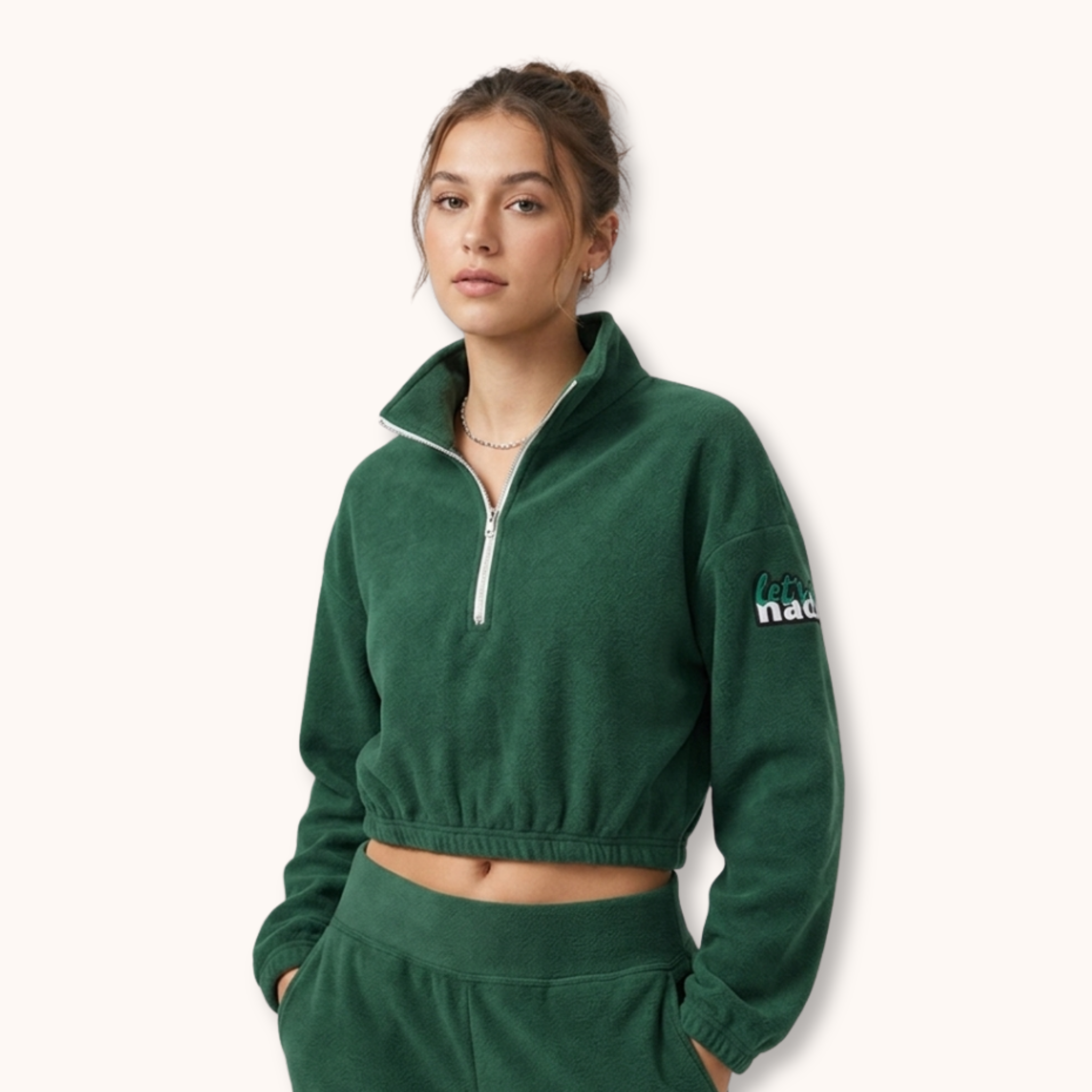 Woman wearing a green fleece pullover with a brand logo on a white background