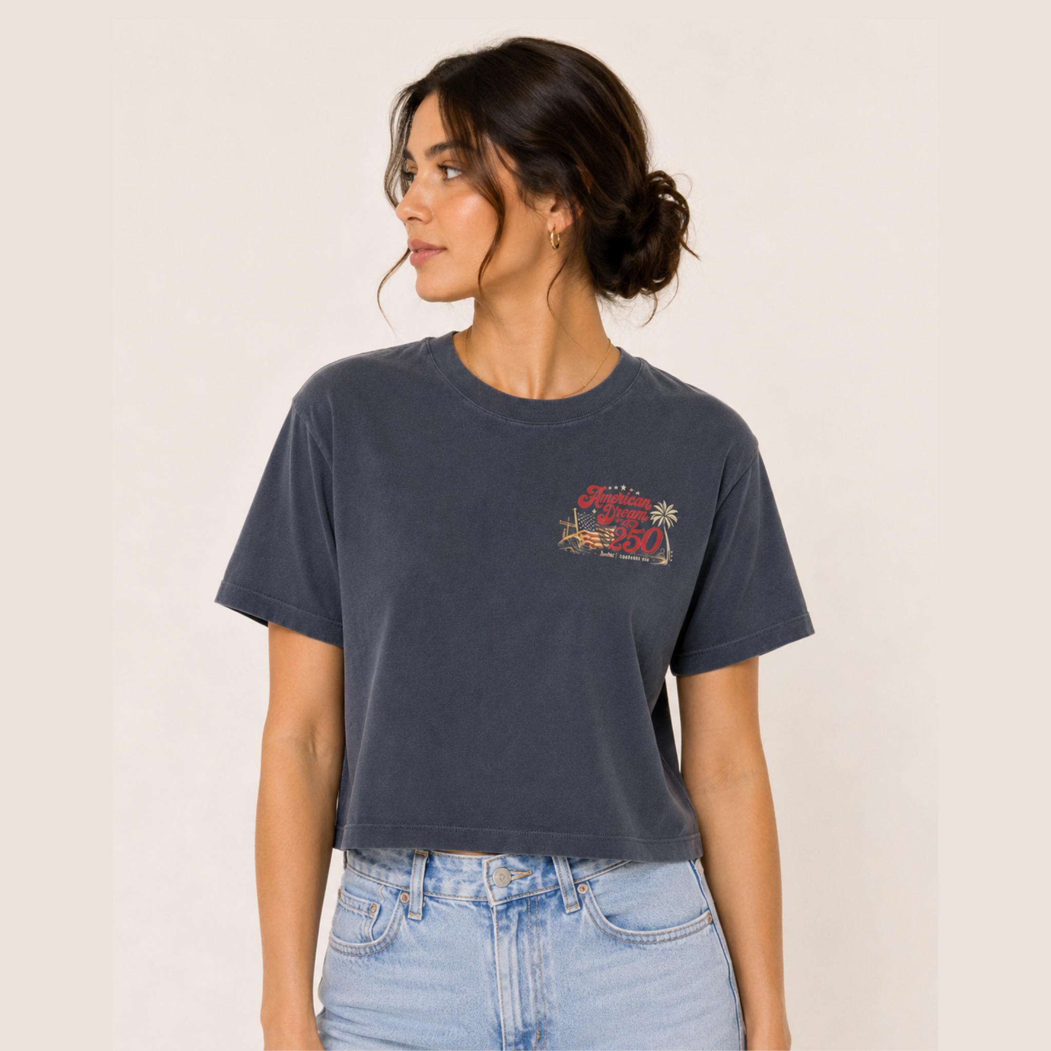 Woman wearing a dark blue t-shirt with a graphic design on a beige background