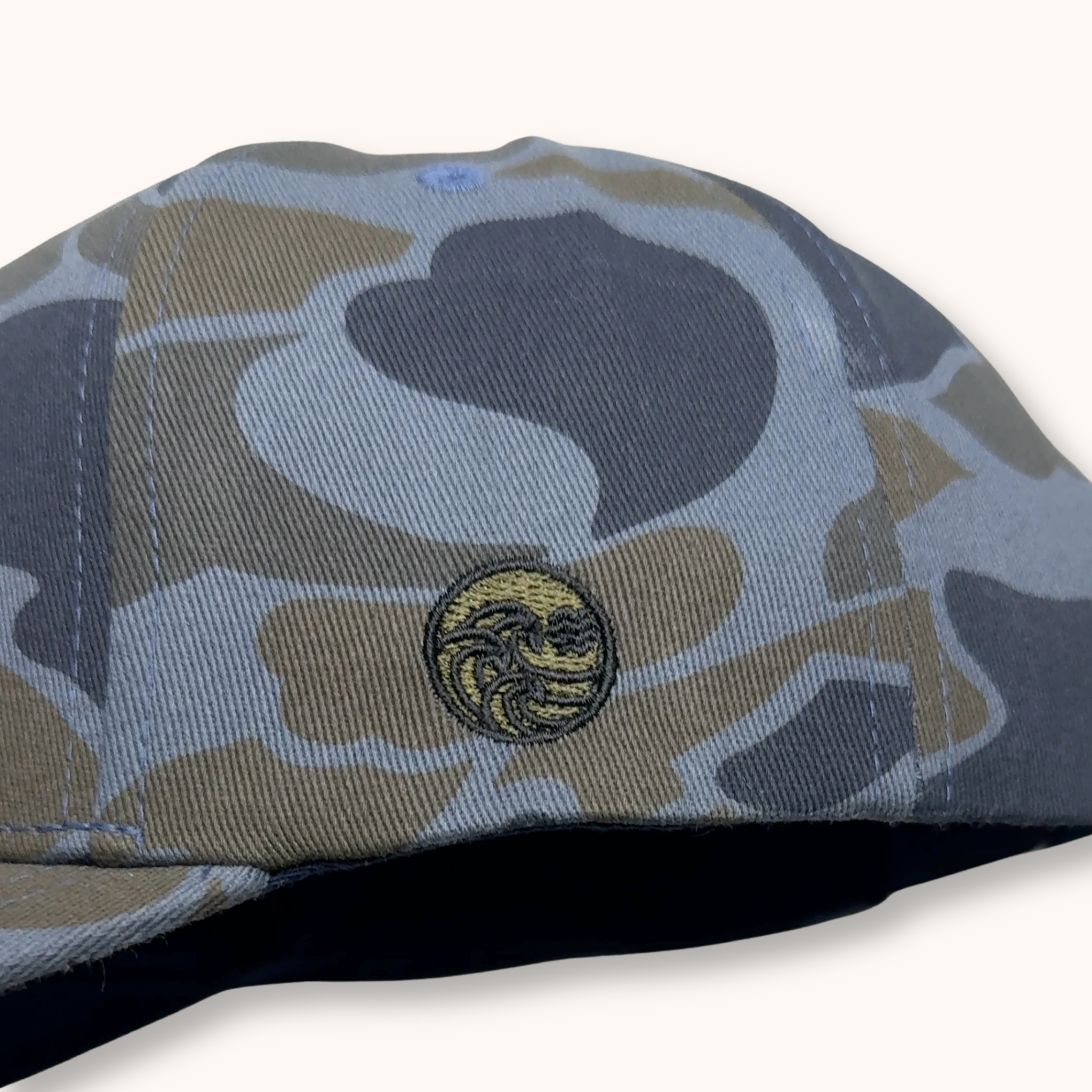 Camouflage-patterned cap with a logo on a white background