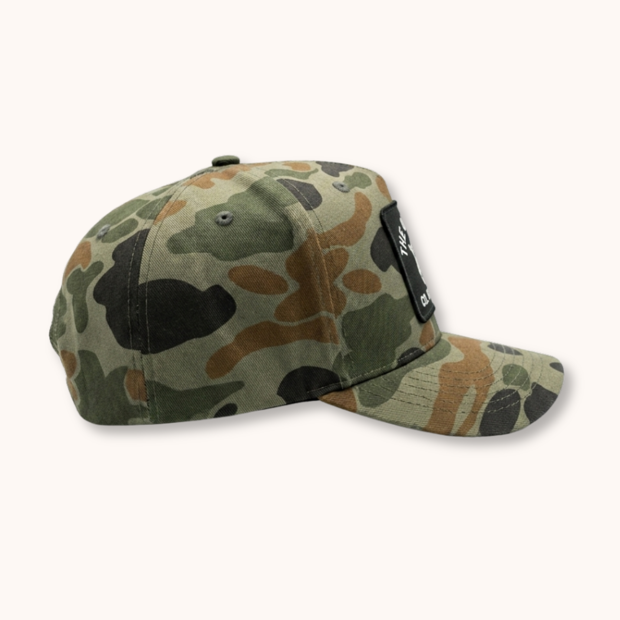 Camouflage-patterned cap with a brand tag on a white background