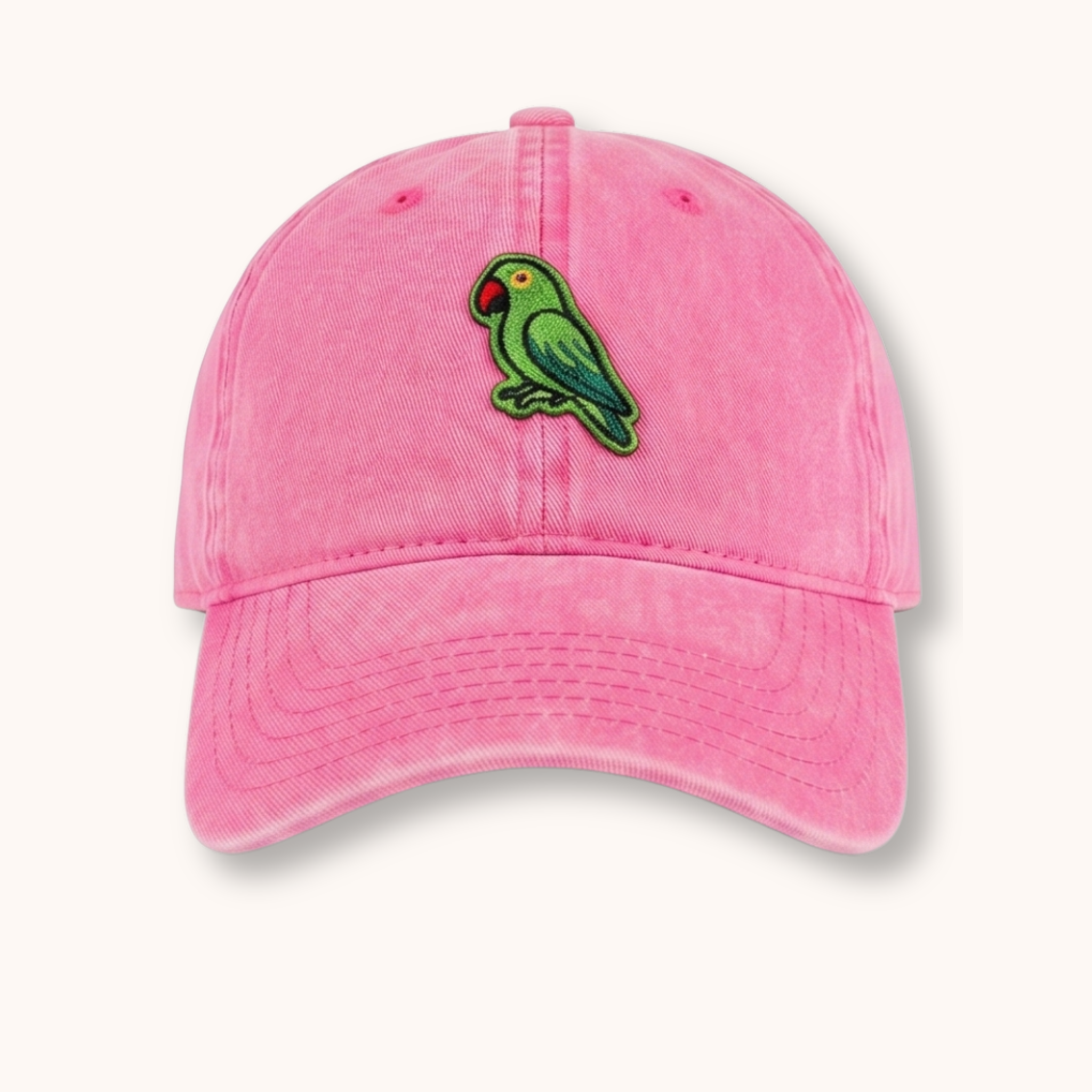 Pink cap with a green parrot emblem on a white background