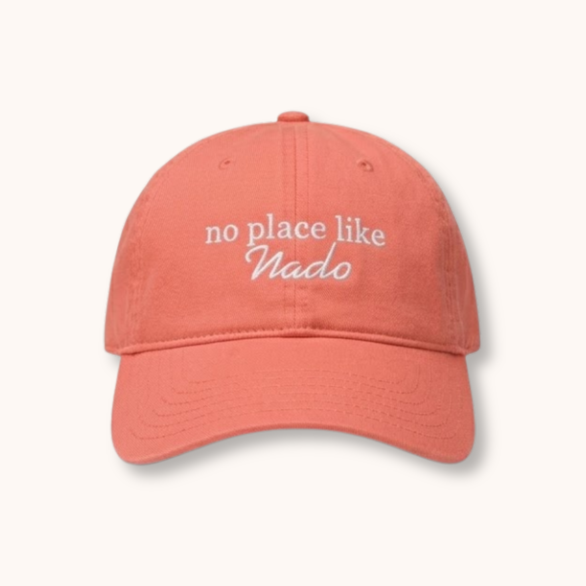 Coral cap with 'no place like Nado' text on a white background