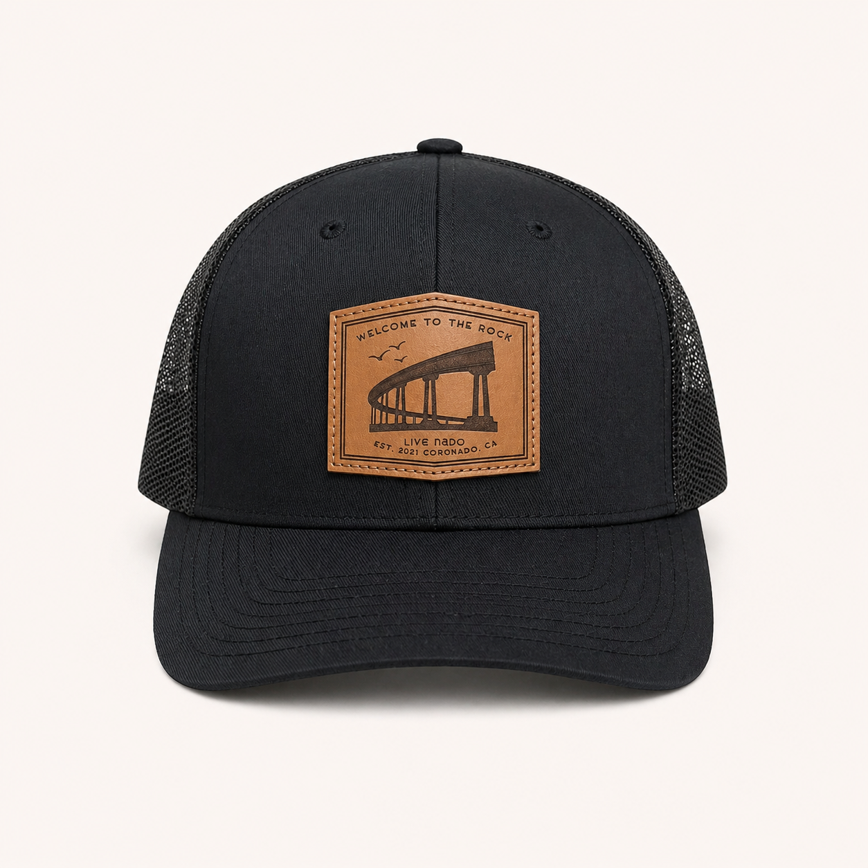 Black trucker cap with a brown leather patch on a white background