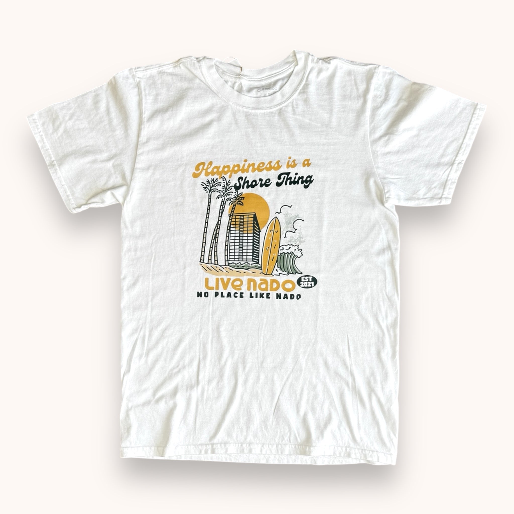 A white crew neck t-shirt with a graphic print of a beach scene and the text 'Happiness is a Shore Thing'. The t-shirt is designed for women.